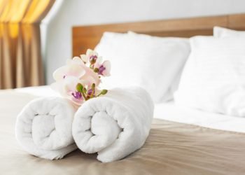 towels and flower on bed in hotel room towels and flower on bed in hotel room